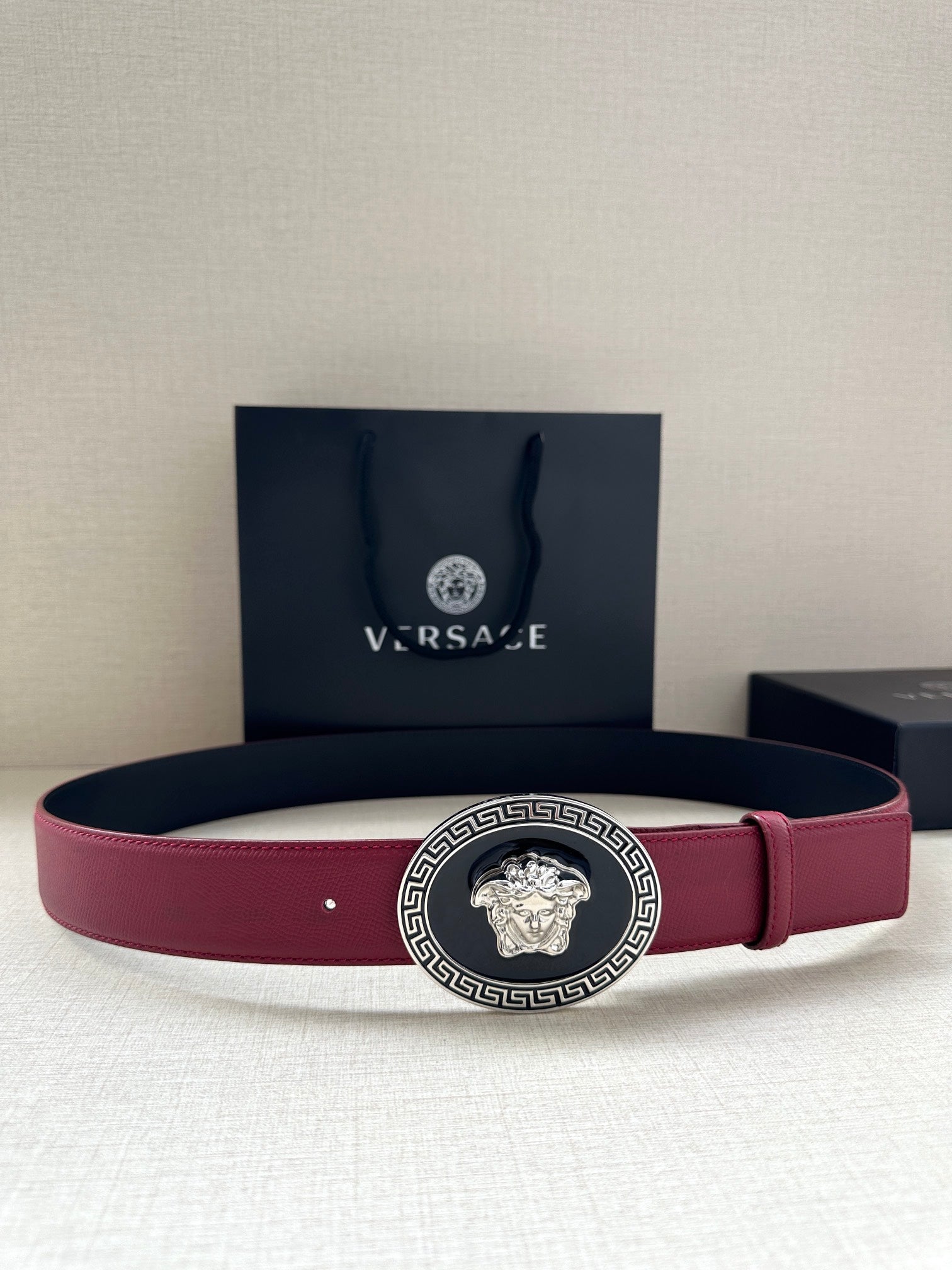 Versace belt with maroon leather strap and gold Medusa buckle with Greek key border
