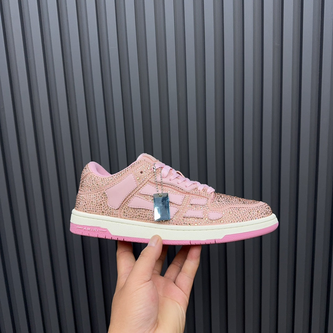 Amiri pink sequin sneakers held up, featuring lace-up front and metallic side tag