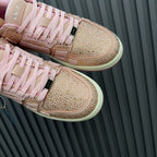 Amiri pink sequin sneakers close-up with lace-up panels, side stripe, and logo tag