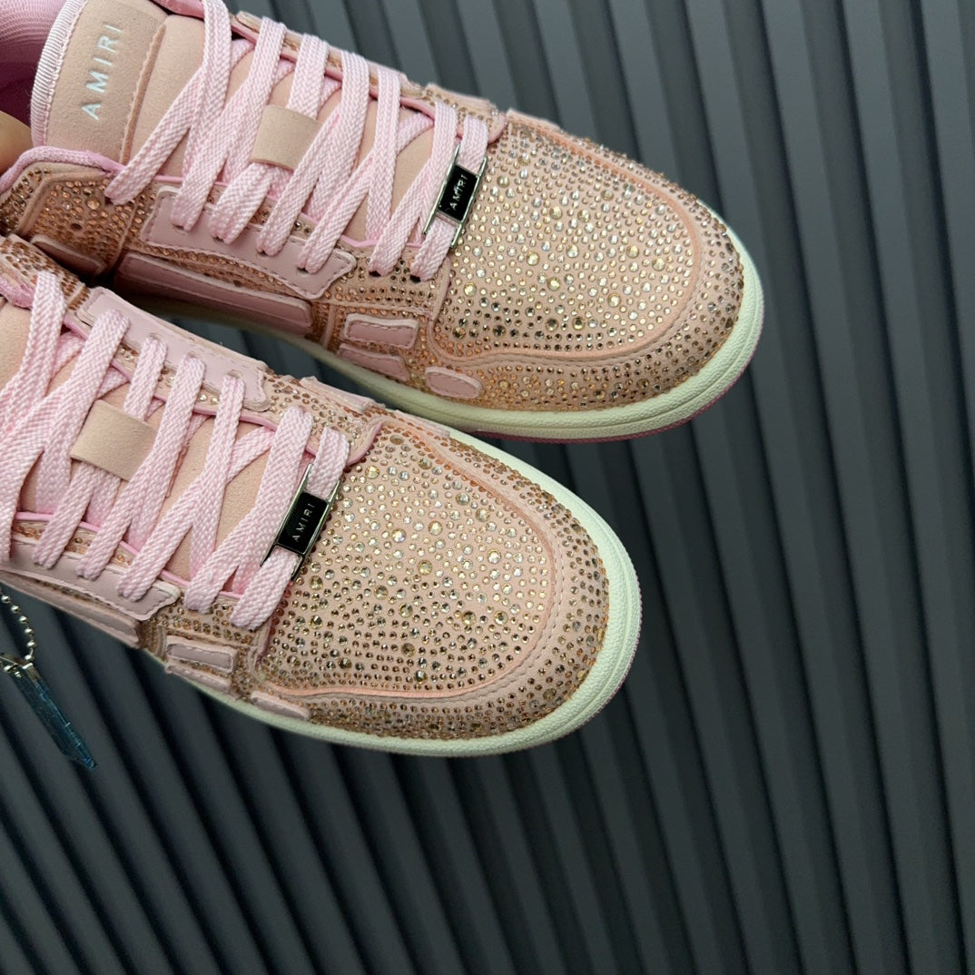 Amiri pink sequin sneakers close-up with lace-up panels, side stripe, and logo tag