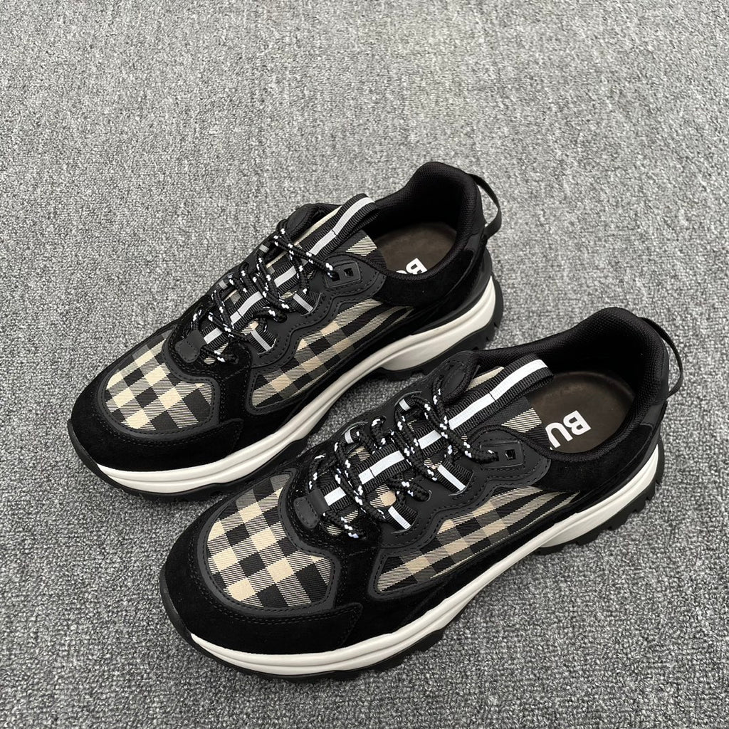 Pair of black sneakers with beige plaid panels, lace-up design, and white midsoles