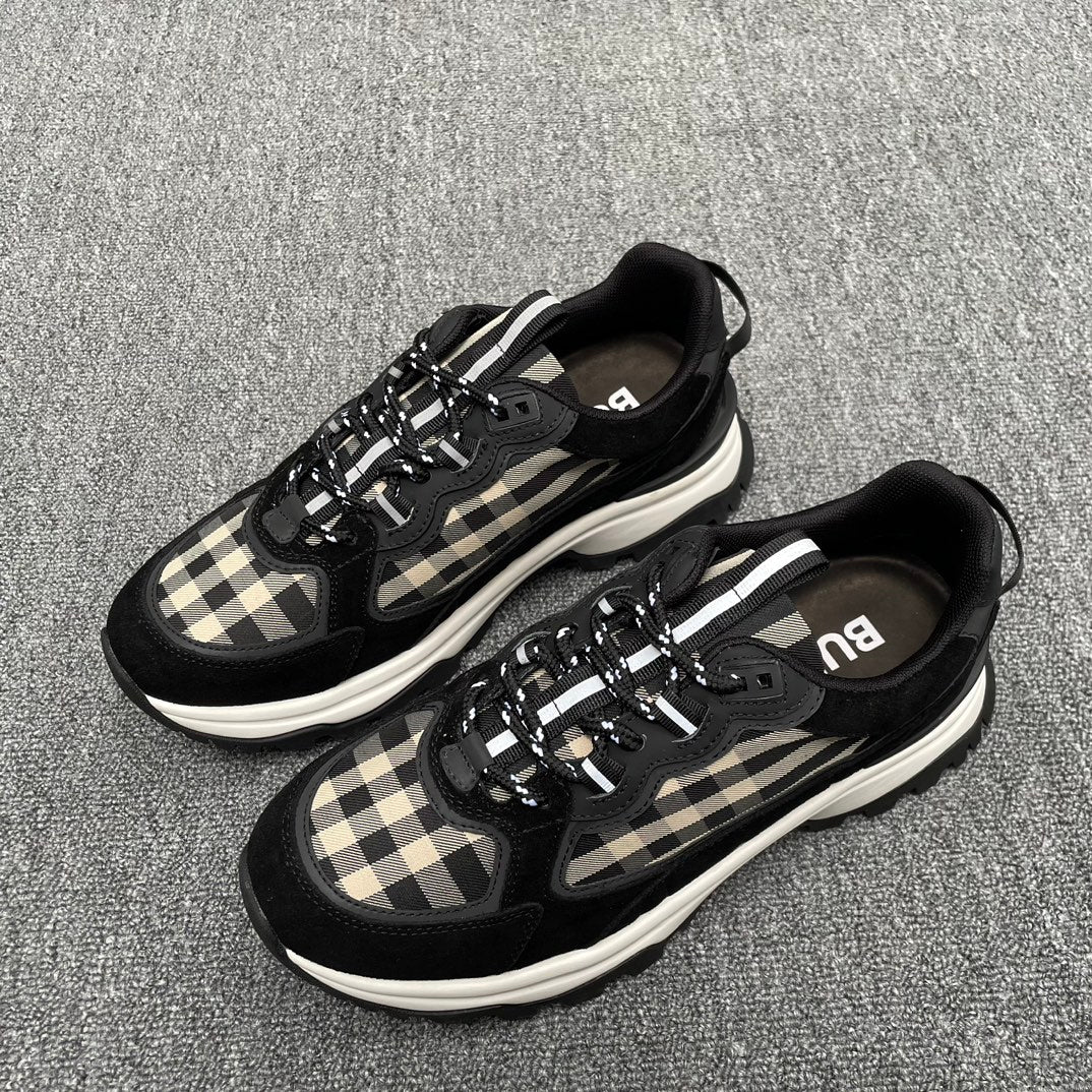 Pair of black sneakers with beige plaid panels, lace-up design, and white midsoles