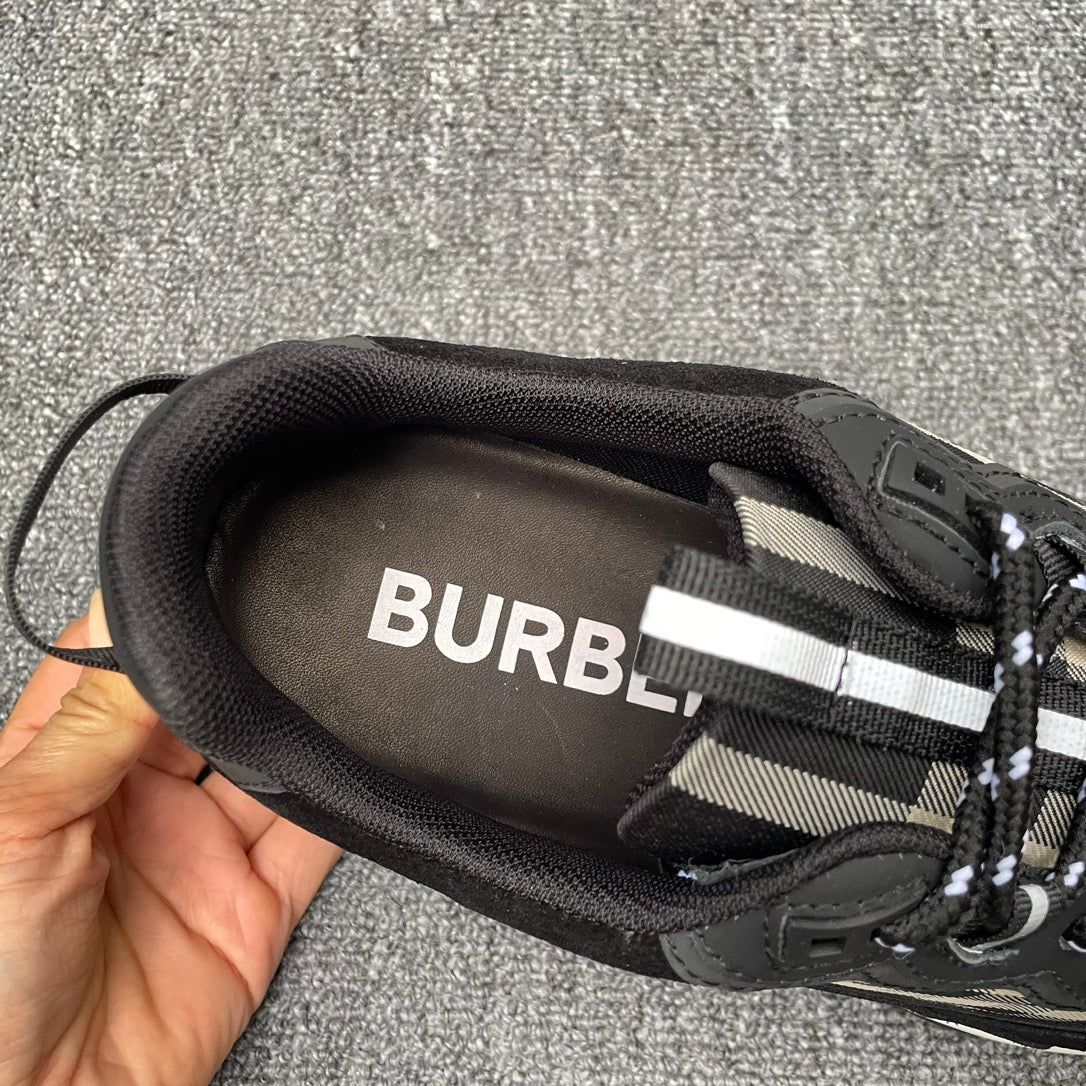 Black sneaker interior with visible insole text and beige check trim near laces