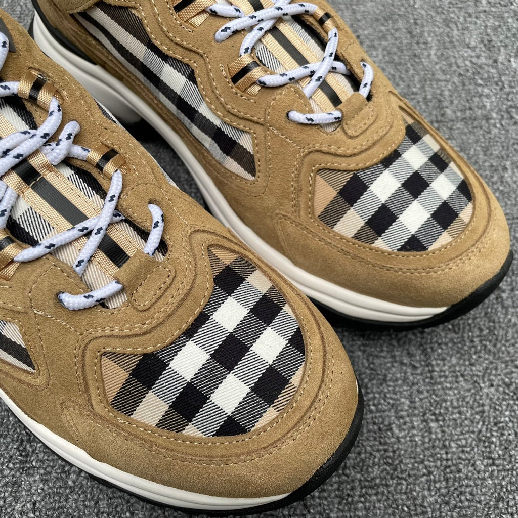 Close-up of tan suede sneakers with Burberry check side panels and white lace-up