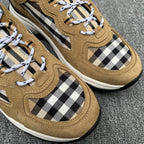Close-up of tan suede sneakers with Burberry check side panels and white lace-up