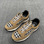 Pair of tan suede sneakers with Burberry check inserts, white laces, and white soles