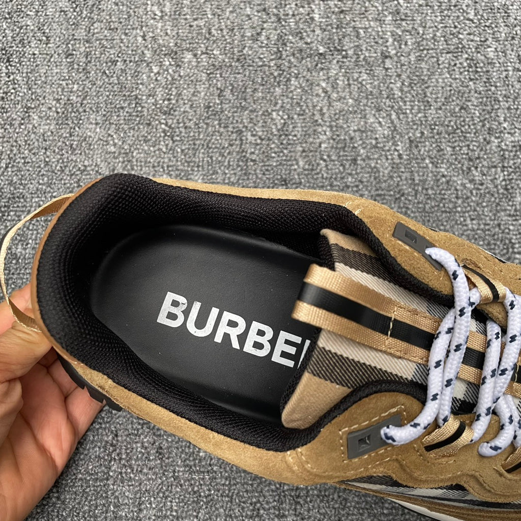 Inside view of tan sneaker heel with black lining showing “BURBERRY”