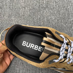 Inside view of tan sneaker heel with black lining showing “BURBERRY”