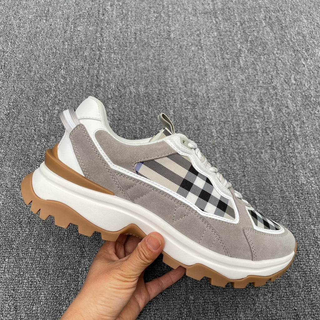 Gray low-top sneaker with black-and-white check stripe detail, white laces, chunky sole