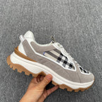 Gray low-top sneaker with black-and-white check stripe detail, white laces, chunky sole