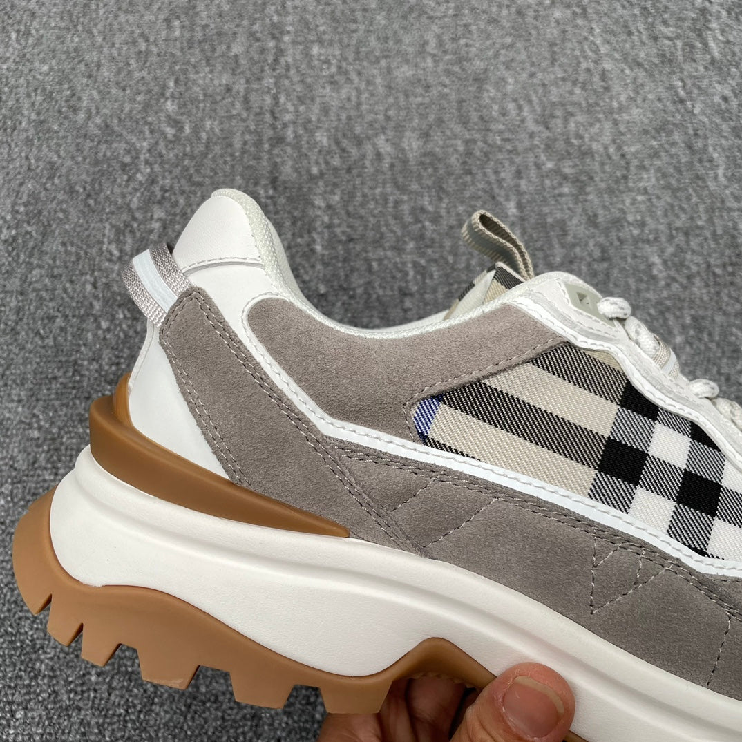 Gray sneaker upper close-up with checkered panel, white laces, thick gum sole