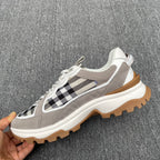 Gray low-top sneakers with black-and-white check panel, white laces, gum sole