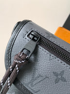 Louis Vuitton bag close-up: gray textured panel with zipper pull and Louis Vuitton logo
