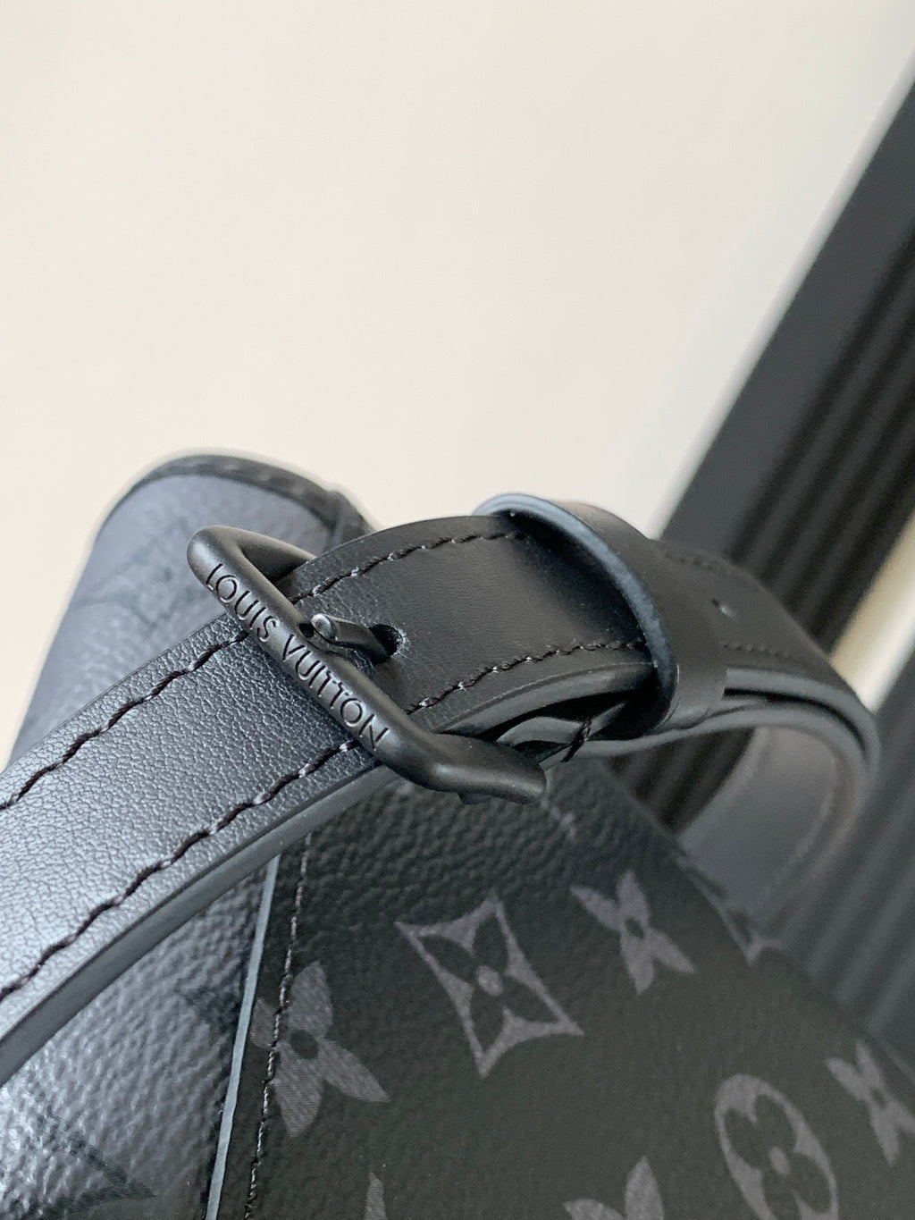Louis Vuitton bag strap close-up with gray leather trim and monogram fabric