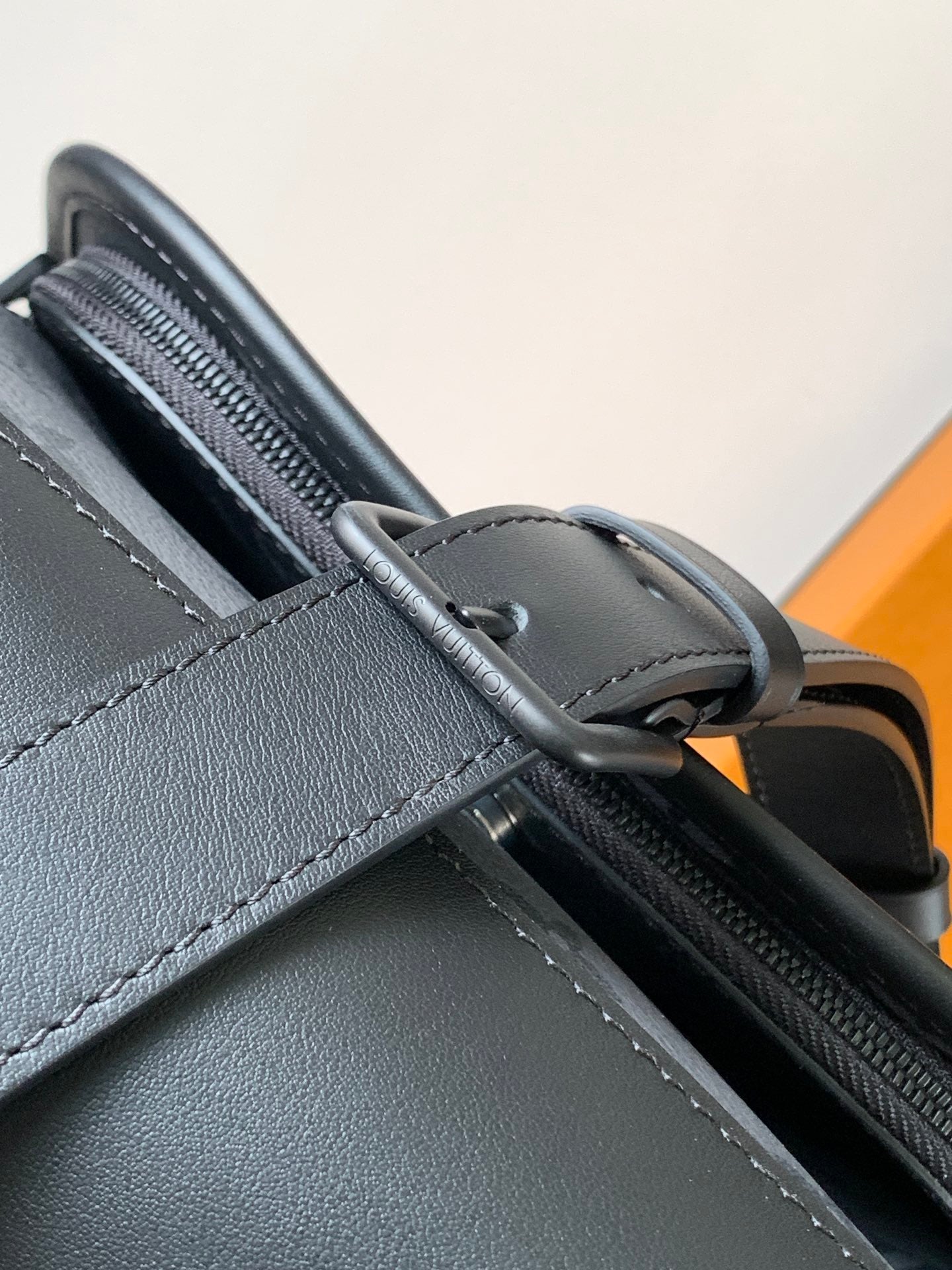 Louis Vuitton monogram bag strap close-up with zipper edge and stitched trim