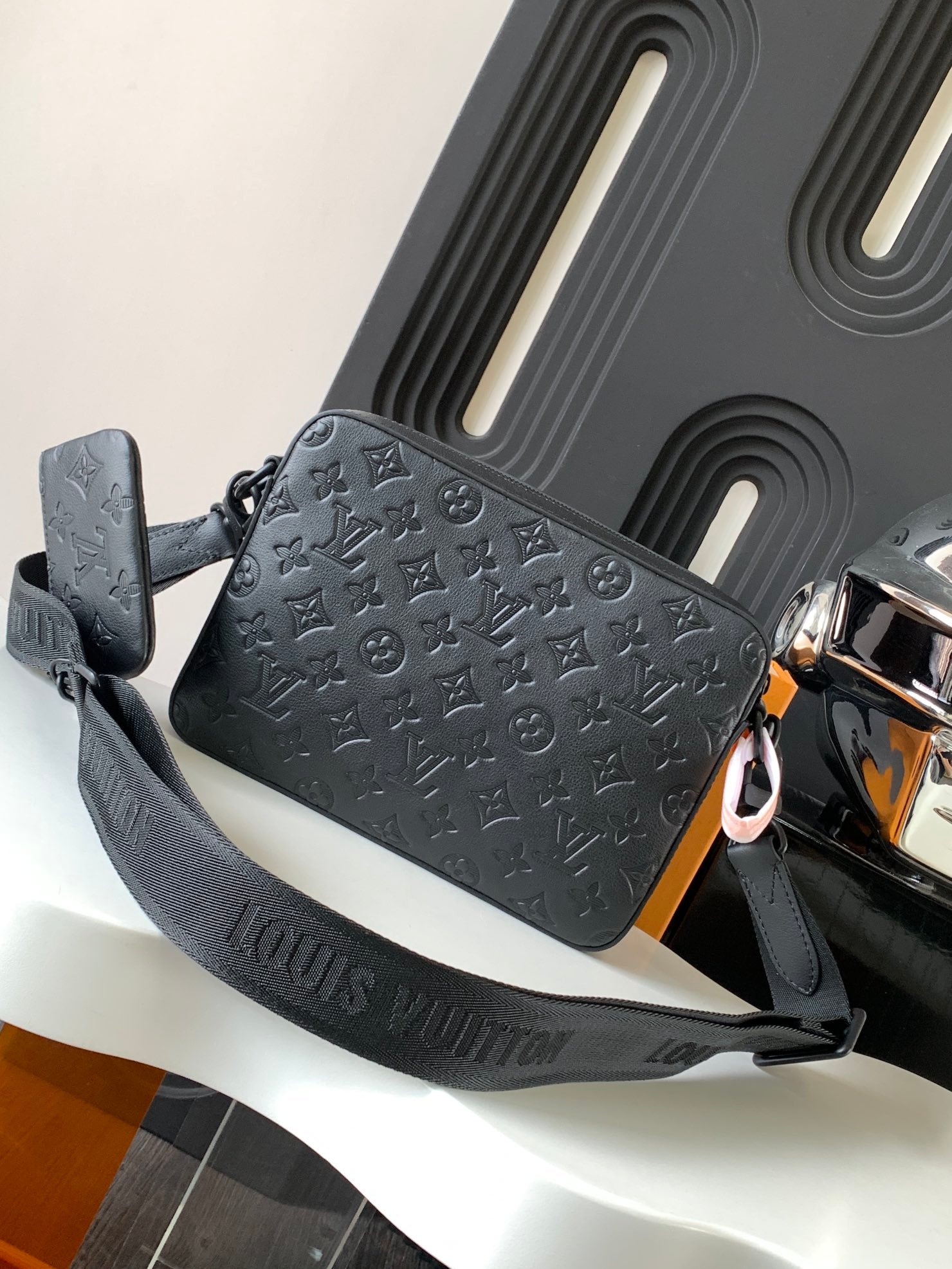 Louis Vuitton monogram crossbody bag, dark gray embossed logo print and shoulder strap