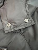Gray long puffer jacket cuff with snap buttons and stitched trim.