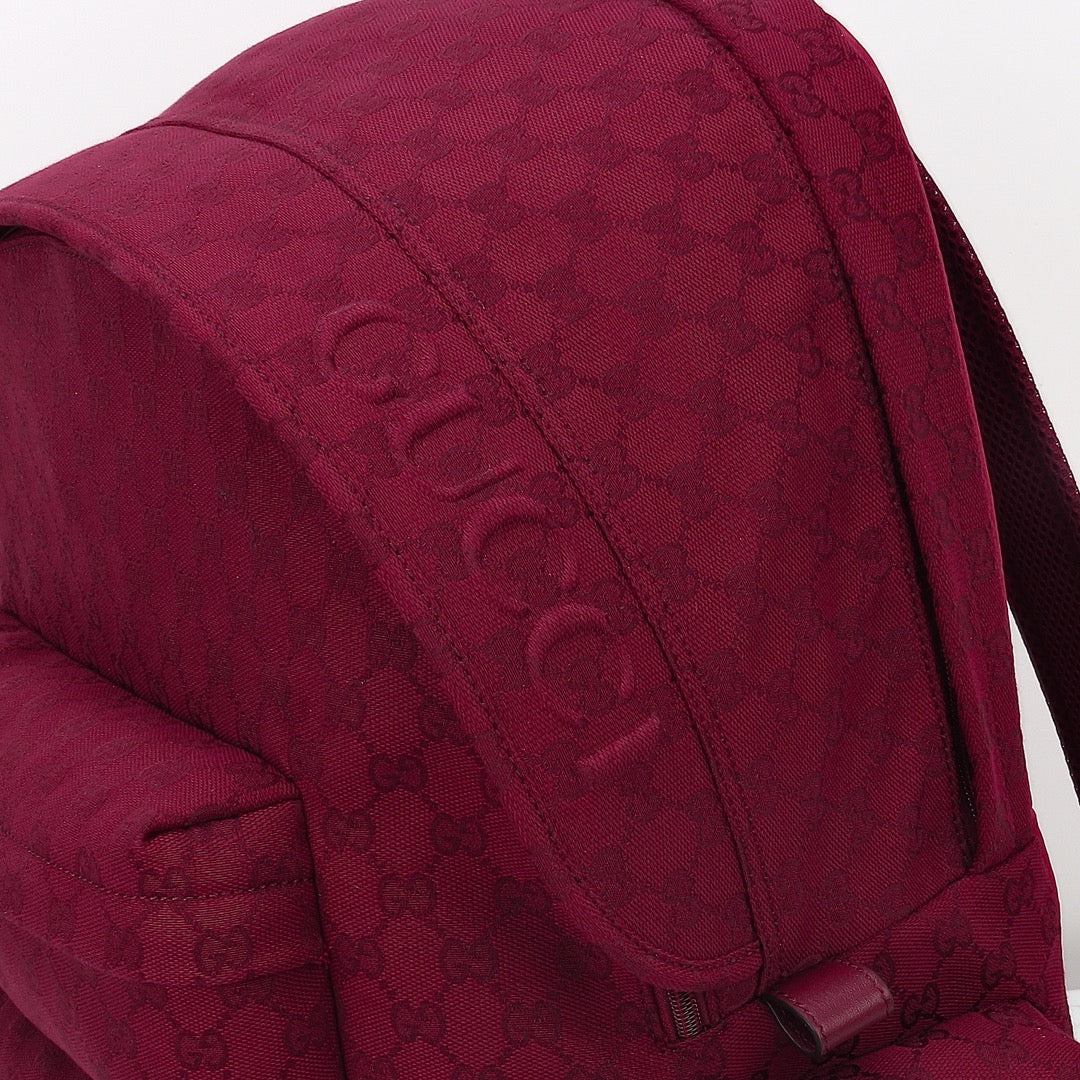 Gucci burgundy GG-pattern backpack side view with stitched seams and strap