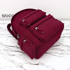 Gucci burgundy monogram duffel bag with top handle, front flap, and multiple buckle straps
