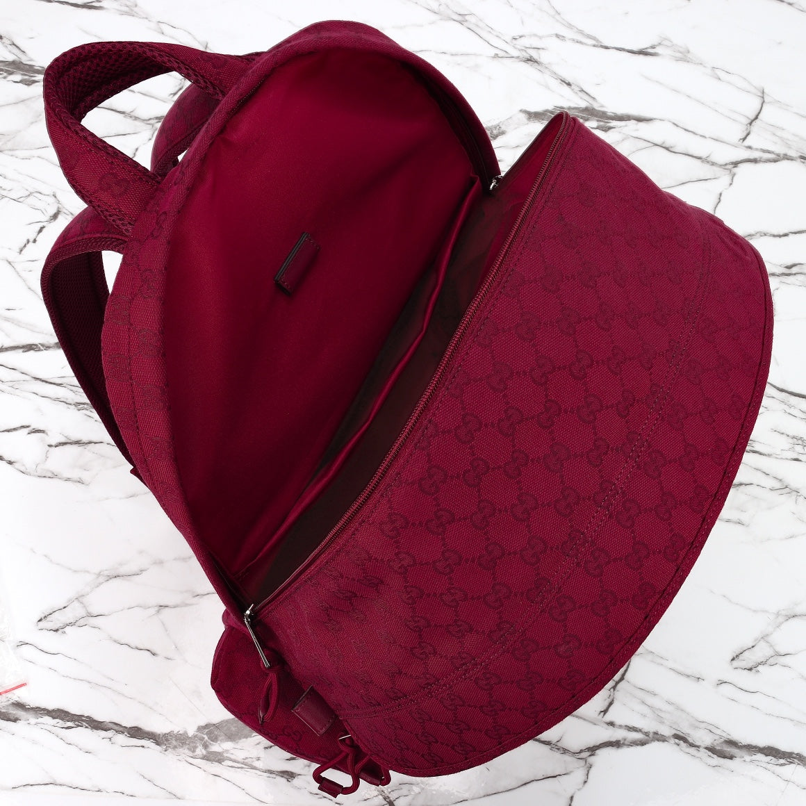 Gucci burgundy duffel bag with open top and interior lining, monogram fabric and zipper