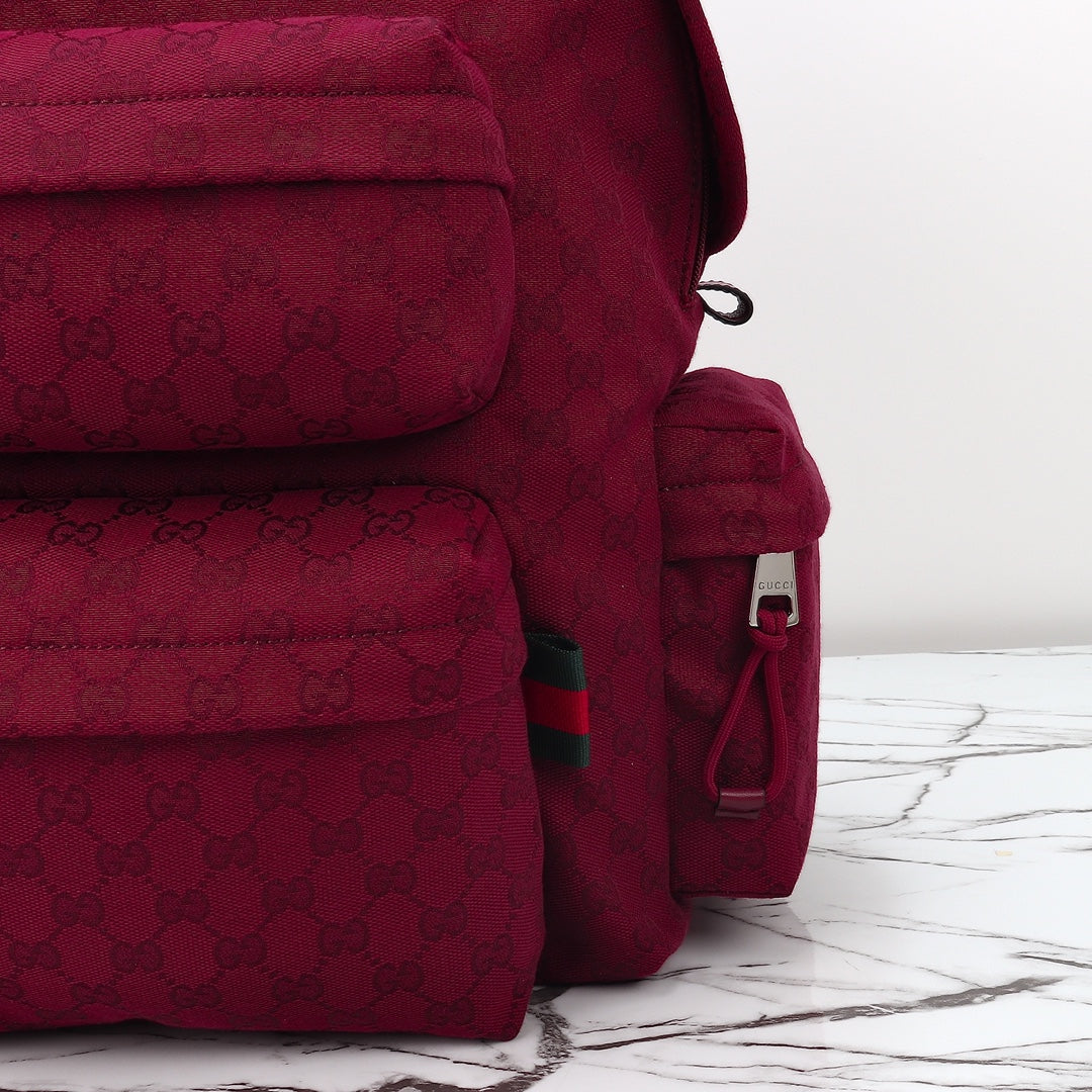 Gucci burgundy GG-pattern backpack with side logo patch, zipper pull, and pocket