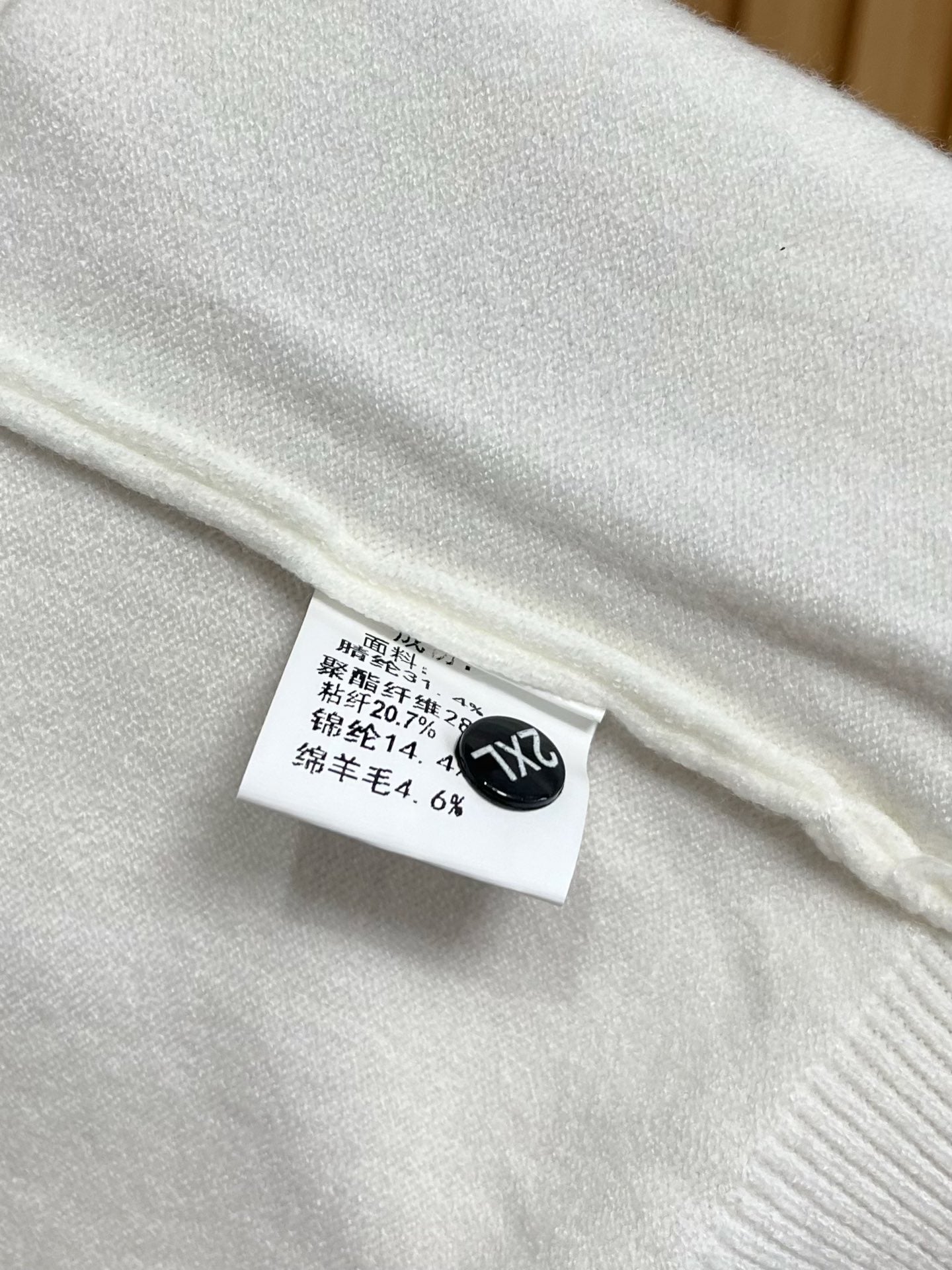 Gucci white sweater with stitched fabric composition label near hem