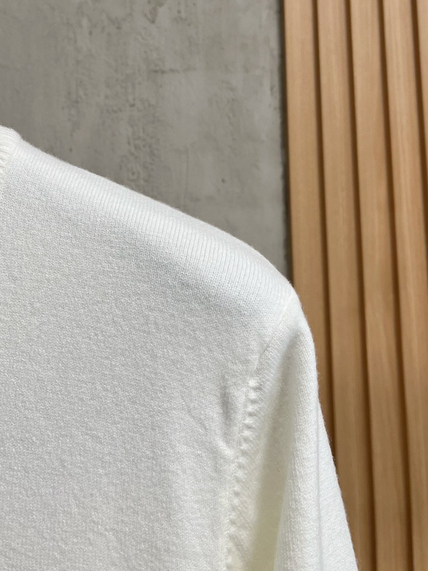 White sweatshirt shoulder with textured knit and stitched seam detail