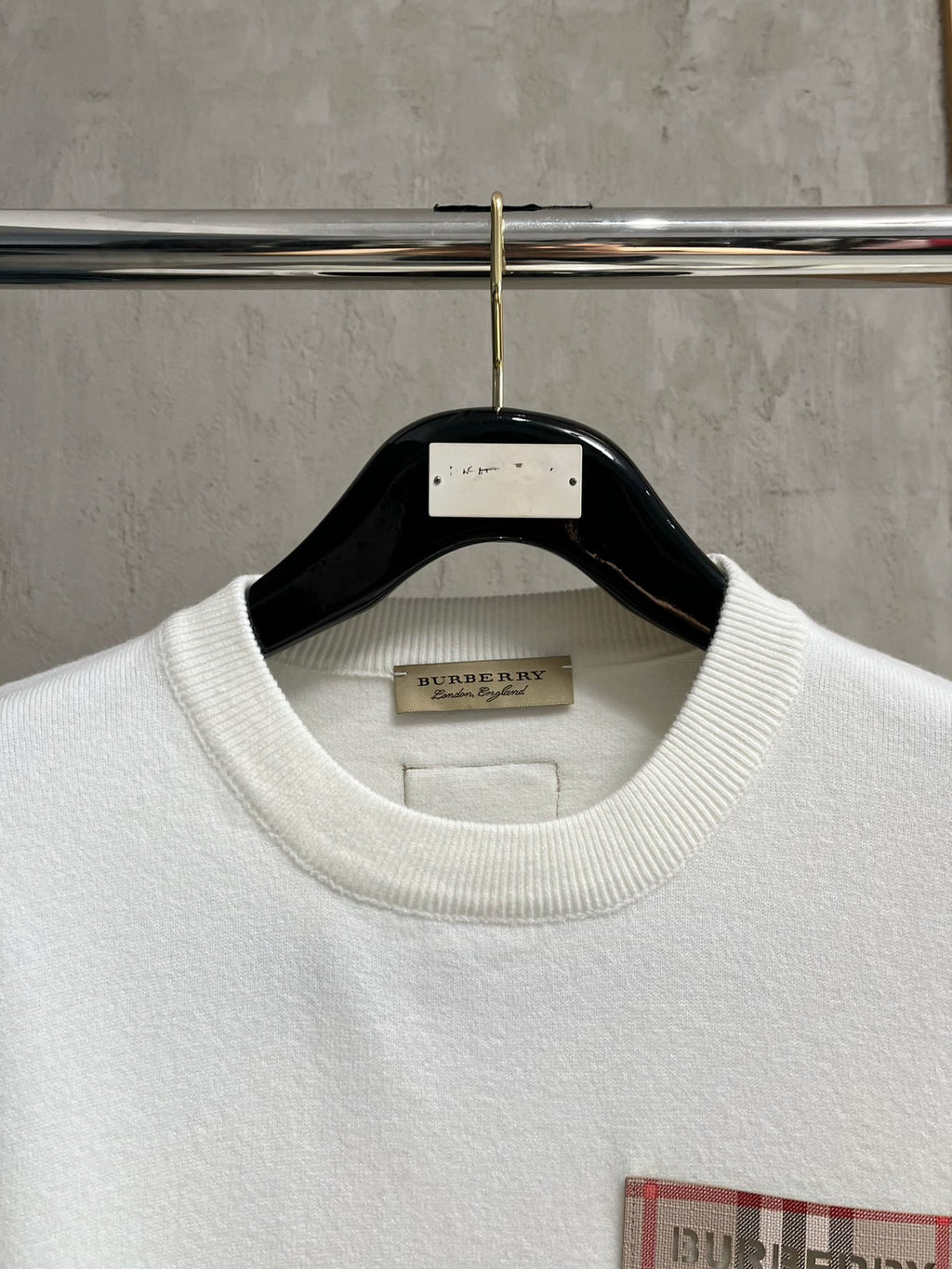 White crewneck sweatshirt neckline with ribbed collar and interior neck label