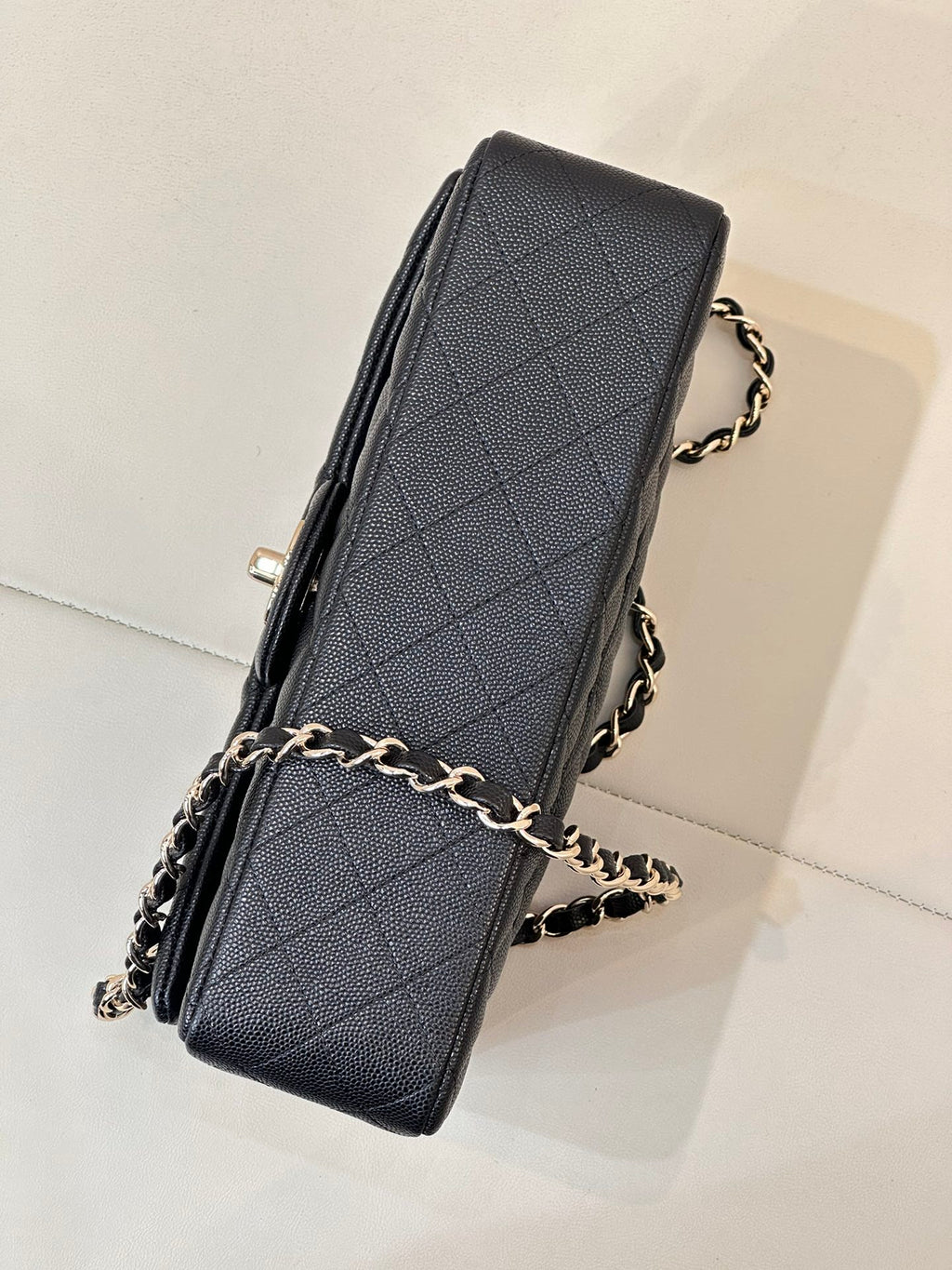 Chanel dark navy quilted shoulder bag side view with chain strap and logo