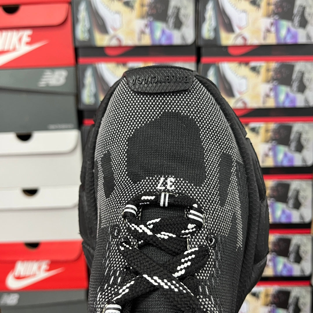 Black sock-style sneaker tongue with white graphic and lace-up opening