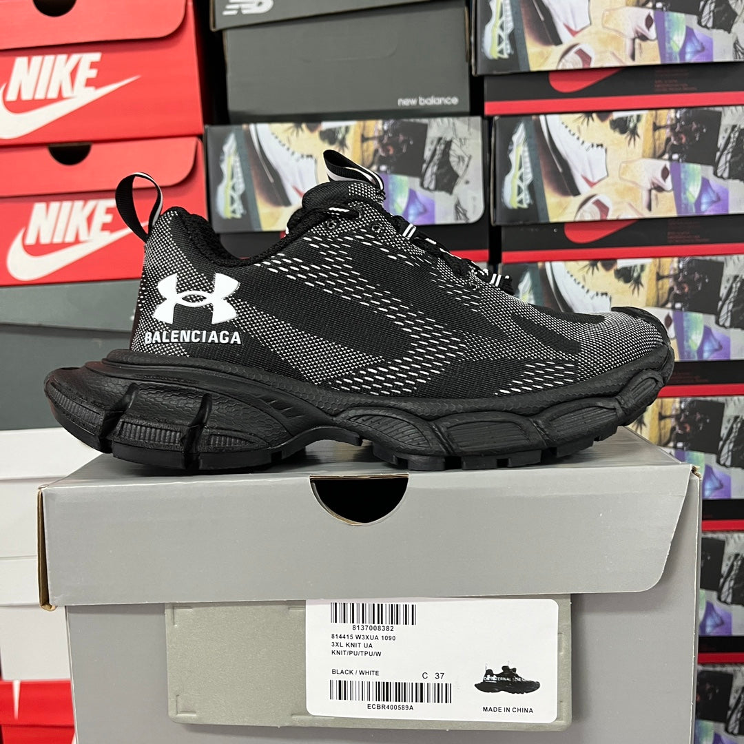 Black knit sneaker on box, lace-up with white logo, thick tread sole