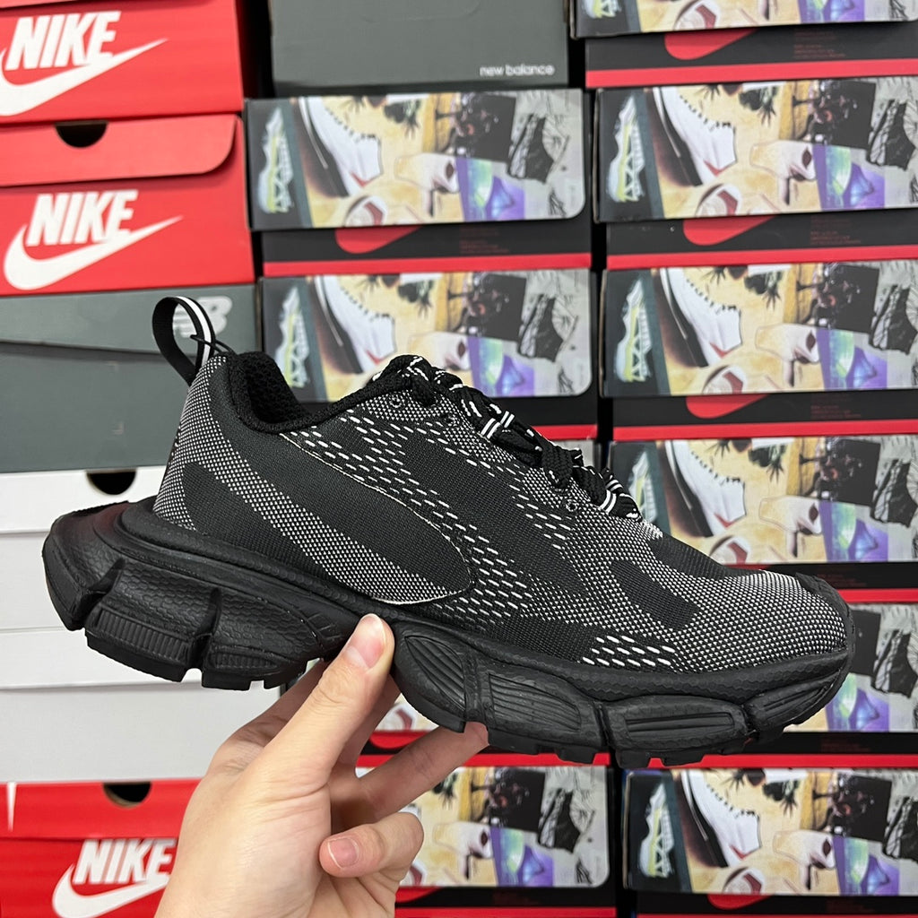 Black knit lace-up sneaker front view with white logo stripes and chunky sole