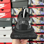 Black knit sneaker back view with white heel print and chunky outsole