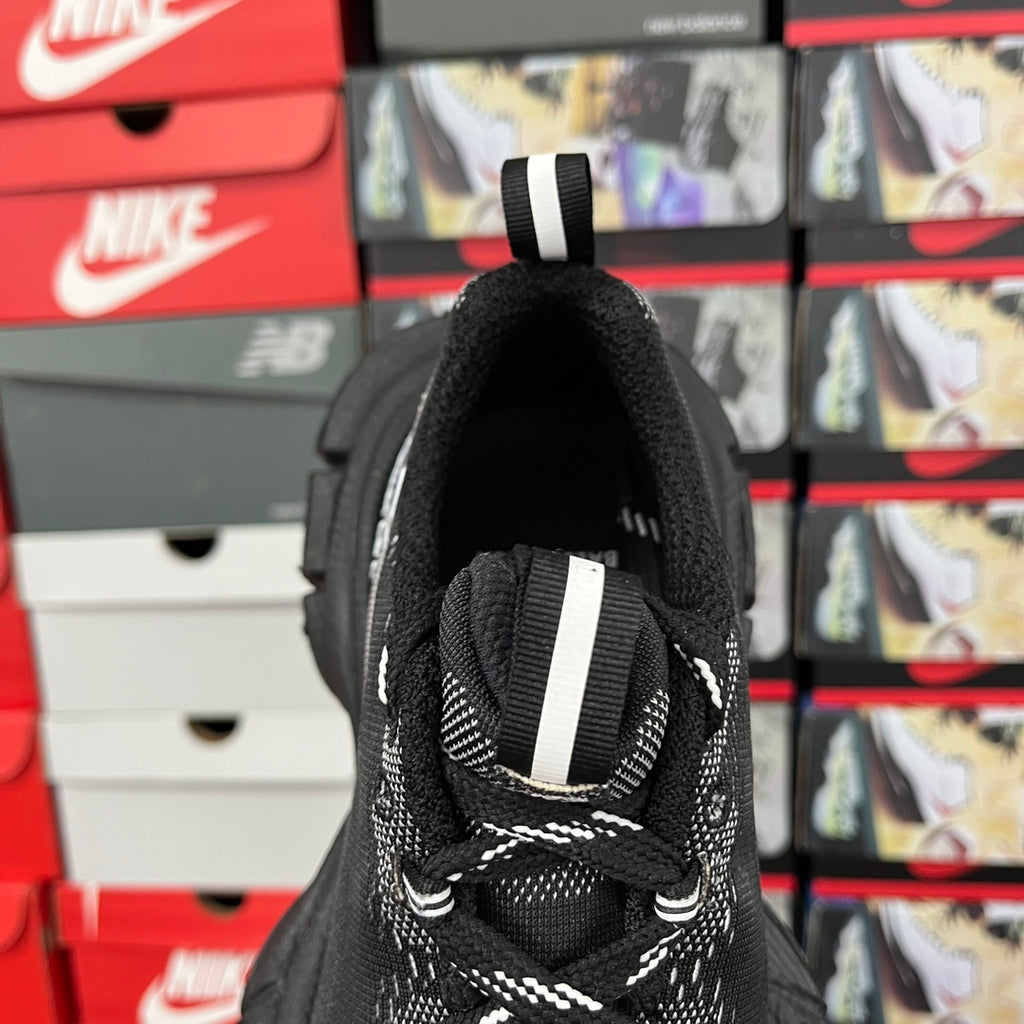 Black sock-style sneaker heel with white strap detail and lace-up opening