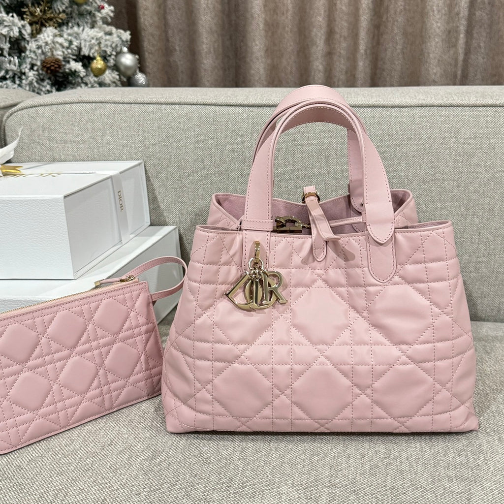 Pink quilted tote bag with top handles and gold-tone logo charm, plus matching clutch