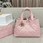 Pink quilted tote bag with top handles and gold-tone logo charm, plus matching clutch