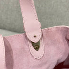 Pink bag strap attachment with stitched loop and small gold-tone button detail