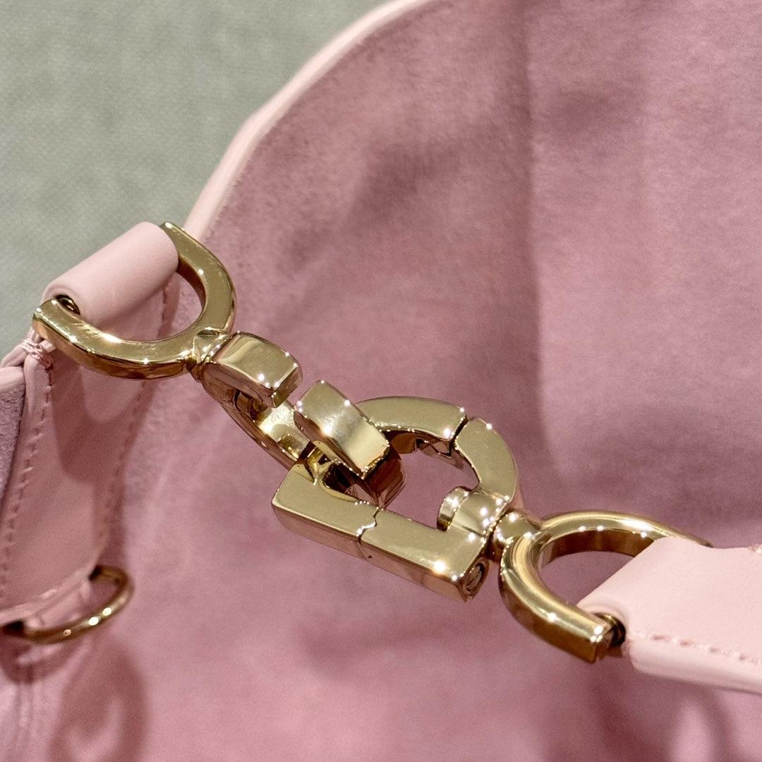 Pink quilted bag strap with gold-tone clasp hardware and interior lining