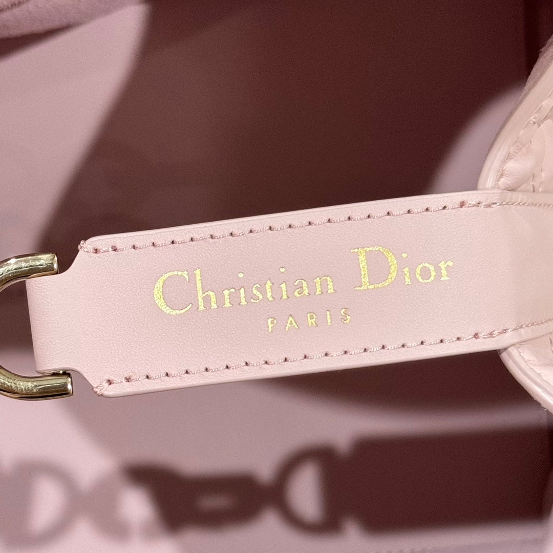 Pink leather tag on bag strap reading “Christian Dior PARIS” with gold-tone hardware