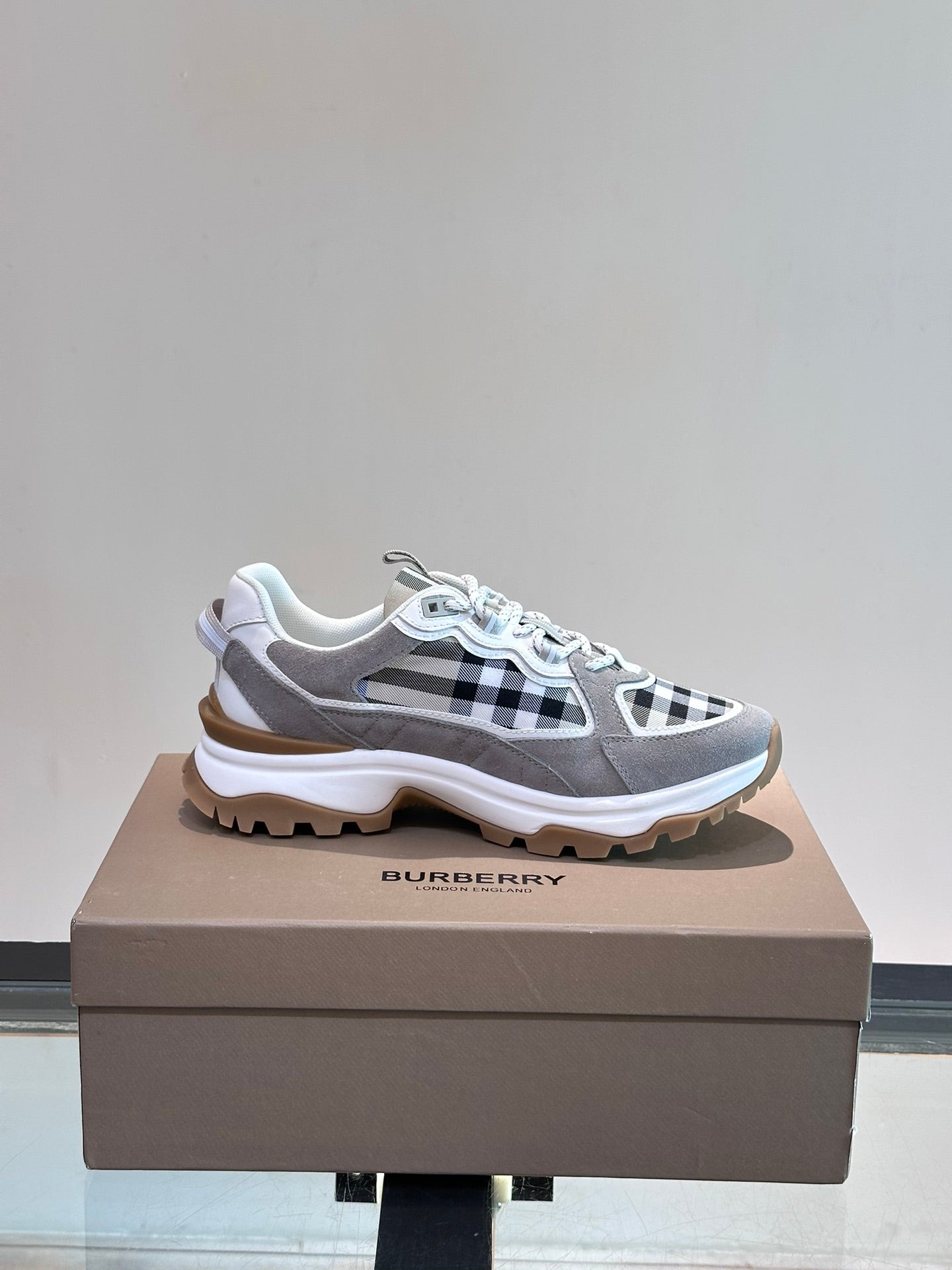 Burberry grey lace-up sneakers with black-and-white check side panel and tan outsole
