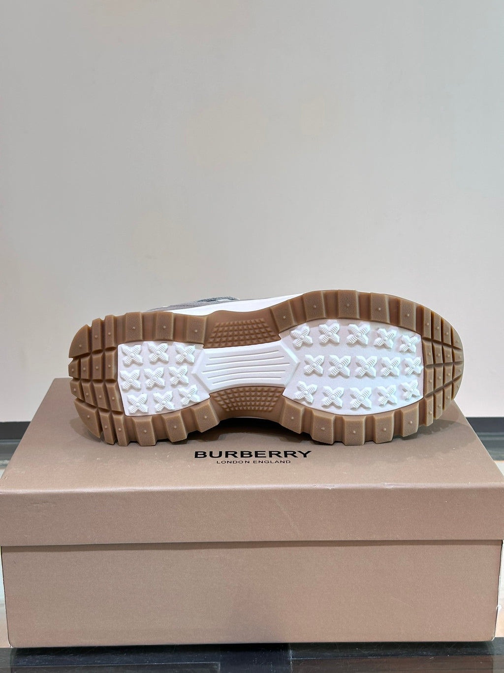 Burberry sneakers outsole view with tread pattern and brown rubber sole base