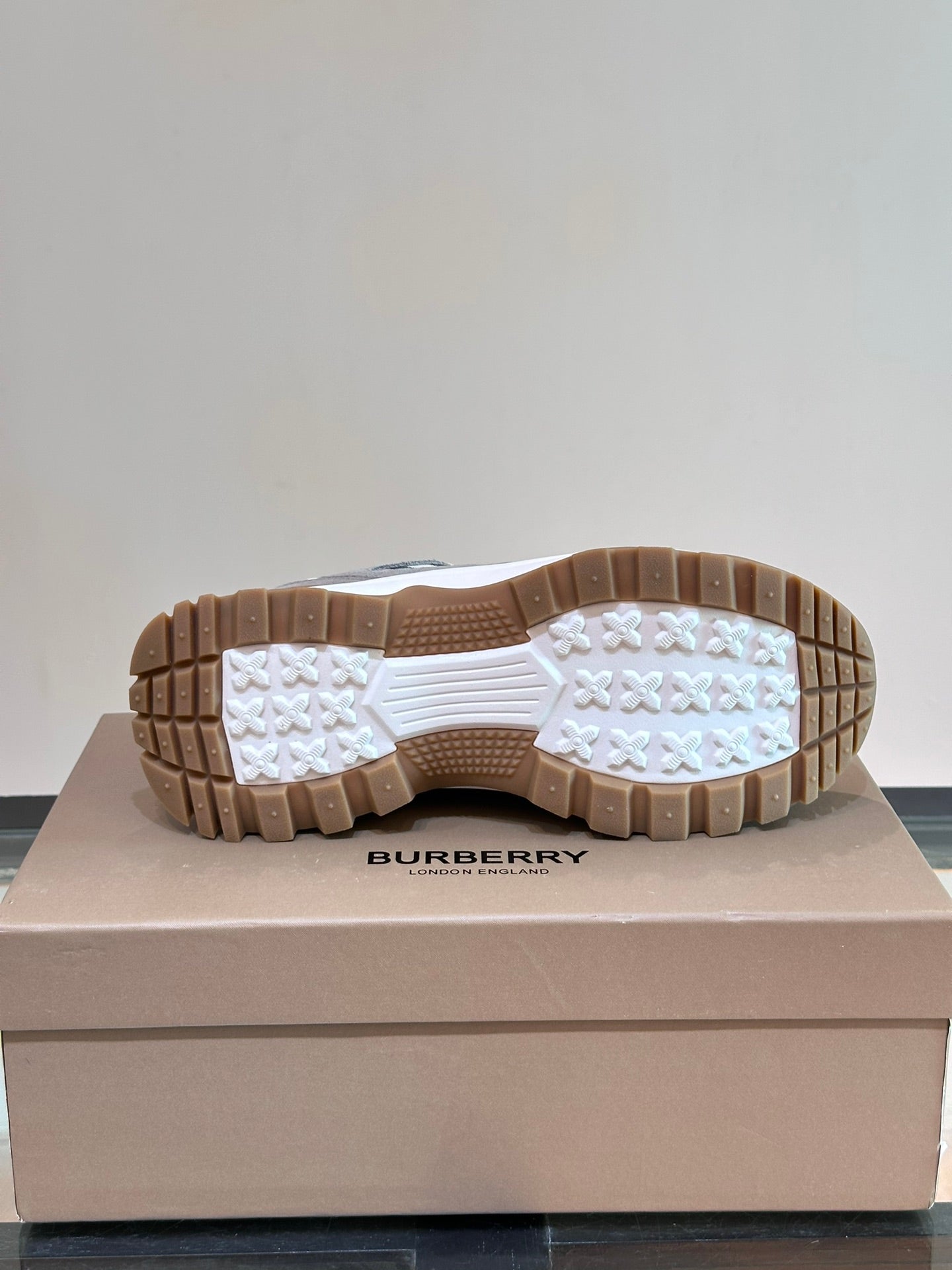 Burberry sneakers outsole view with tread pattern and brown rubber sole base