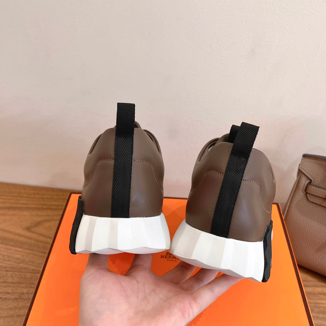 Hermes unisex sneakers heel view, brown leather with black strap and white cushioned midsole