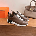 Hermes unisex sneakers pair, brown leather, white laces, black strap detail and thick sole
