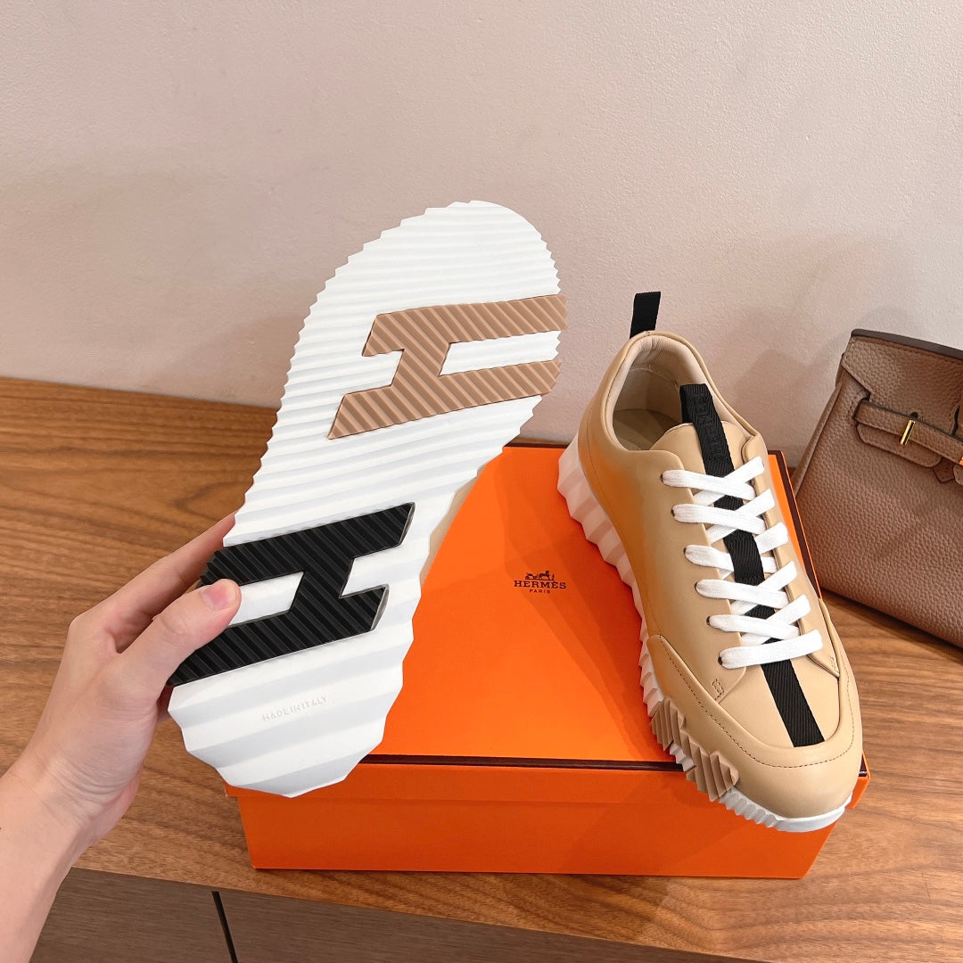 Beige sneaker with black-and-white rubber outsole, white laces, black side stripe