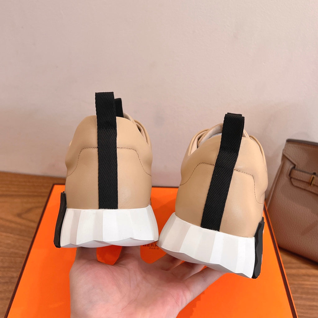 Beige leather sneakers with white laces, black heel straps, white midsole band