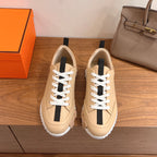 Beige leather low-top sneaker with white laces and black side stripe, rubber sole