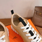 Beige leather sneaker upper with white laces and black strap panel, cushioned collar