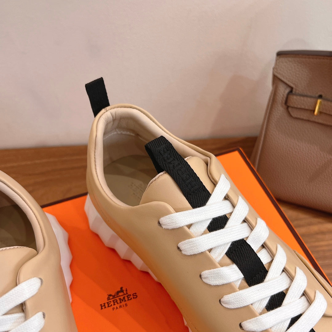 Beige leather sneaker upper with white laces and black strap panel, cushioned collar