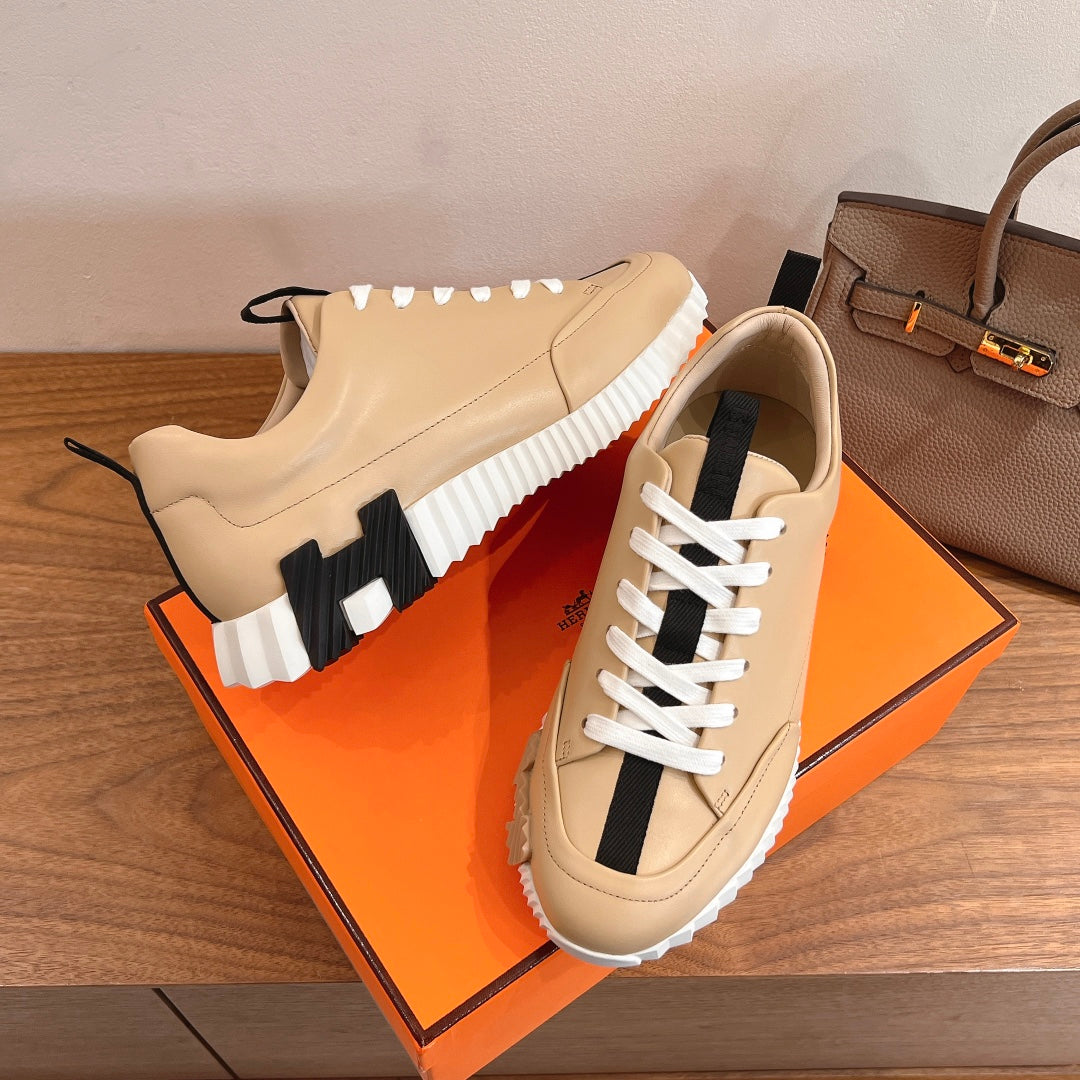 Beige leather sneaker pair with white laces, black side stripe and contrast heel tab
